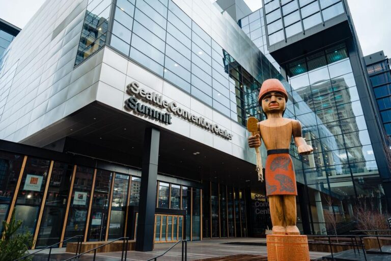 Seattle Convention Center. Steel and glass building with wooden sculpture of an Indigenous figure.