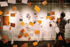 An exhibit at Wing Luke Musuem featuring yellow and white paper suspended from the ceiling by strings.
