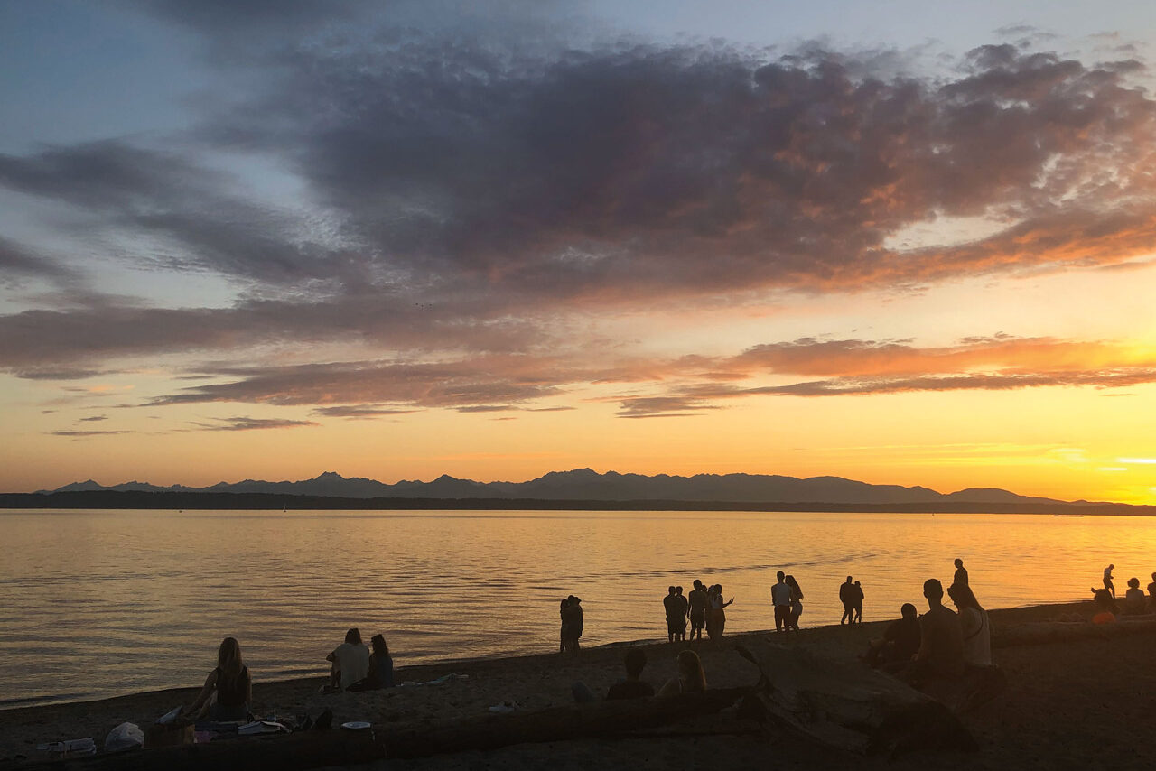 silhouetted people watching sunset at Golden Gardens