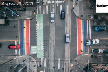 Seattle Capitol Hill crossroads with cars driving though. Shot from the sky looking down. Two rainbow colored crosswalks.