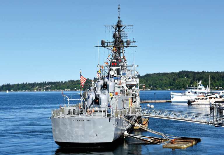 A photo of the USS Turner Joy docked in the water. The USS Turner Joy is a former naval destroyer ship turned museum.