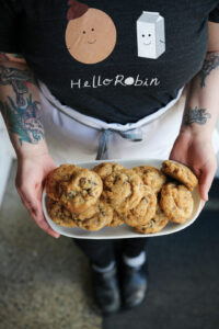 a person wearing a black shirt holding a tray of cookies.