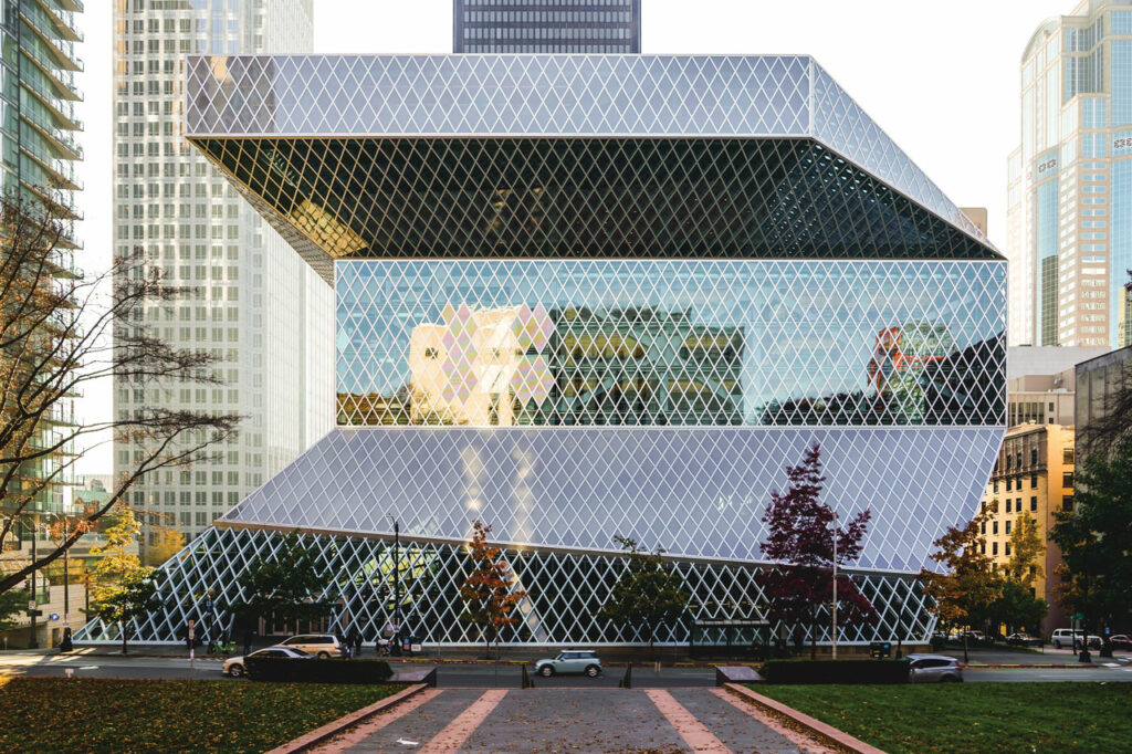 A photo of Seattle's Central Library, a large building made entirely of glass panels shaped like diamonds.
