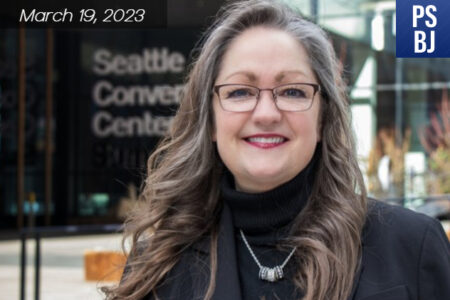White middle-aged woman, headshot of her in front of the Seattle Convention Center - Summit building.