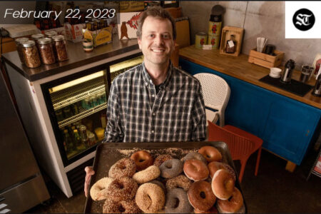 Caucasian midddle aged slim figured man holding a plate full of bagels.