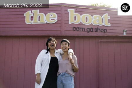 Two Asian women are smiling and standing in front of a red building, restaurant name is 