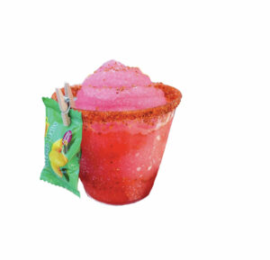 A hot pink drink with a green wrapped candied attached on the left side.