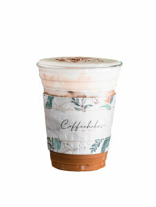 A coffee beverage in a plastic cup with a printed cup sleeve.