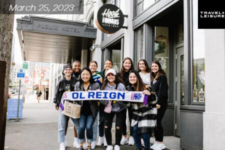 A group of BIPOC women huddled together holding a Ole Reign sign.