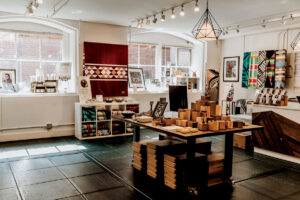 Colorful blankets, jewelry, and homewares fill the inside of a shop.