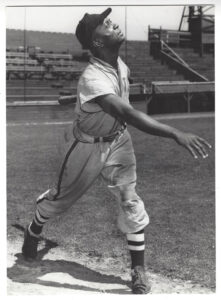 A black and white photo of a baseball player throwing a ball.