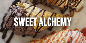 Three ice cream cones lay on their side drizzled with chocolate and caramel sauce.