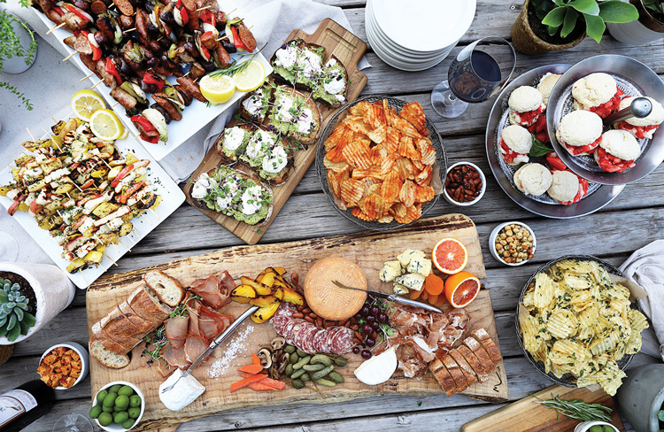 A large spread of colorful charcuterie set on a wooden table